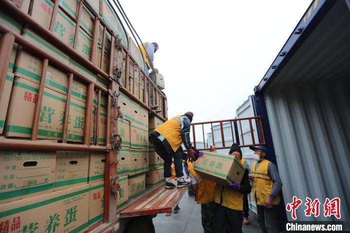 圖為鐵路裝卸作業(yè)人員正在將云南特色農(nóng)產(chǎn)品裝入集裝箱?！詈?攝