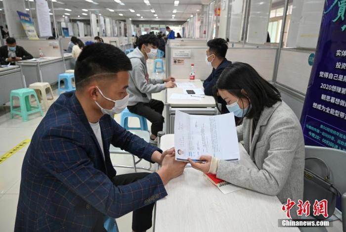 4月14日，招聘者在查看求職者簡(jiǎn)歷。<a target='_blank'  data-cke-saved- >中新社</a>記者 王剛 攝