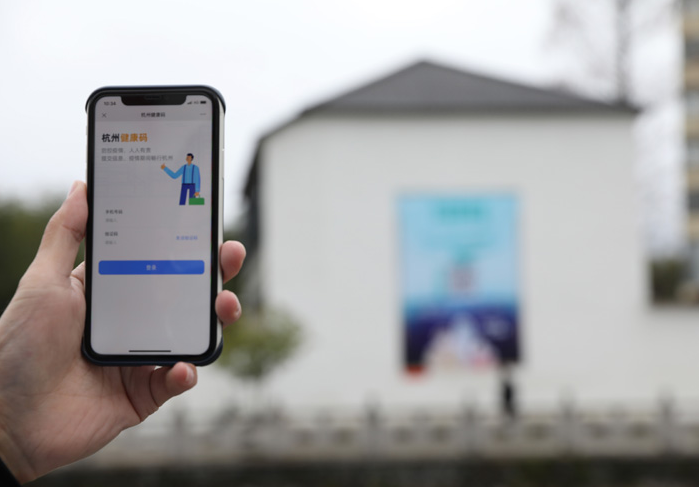 在浙江省杭州市臨安區(qū)天目山鎮(zhèn)，一名居民在“杭州健康碼”海報(bào)上掃碼申領(lǐng)個(gè)人二維碼。新華社發(fā)