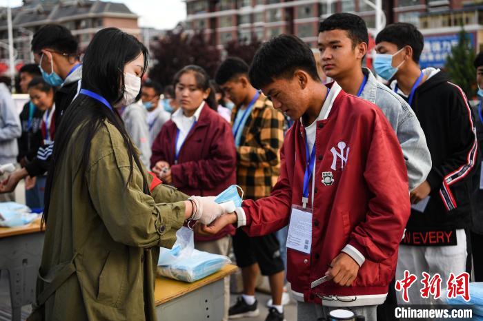 7月7日，考生在拉薩三高考點外測量體溫?！『闻罾?攝